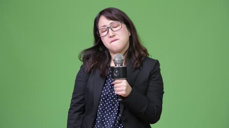 Reife-traurig-asiatische-geschäftsfrau-als-Nachrichtensprecher-mit-Mikrofon