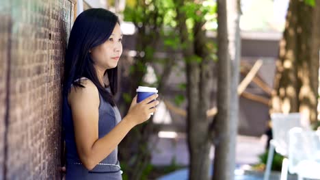 Asiatische-Frauen-trinken-heißen-Kaffee-in-einem-Café-glücklich.