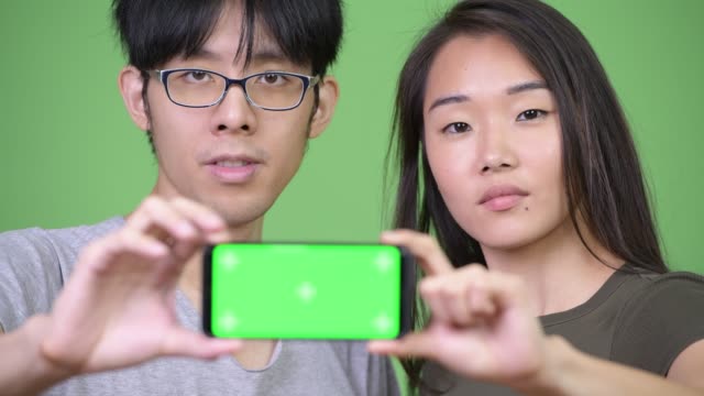 Teléfono-de-muestra-joven-pareja-asiática-junto