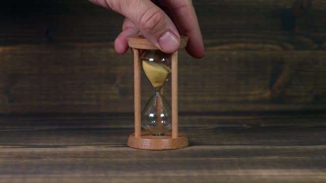 Sandglass-clock-on-wooden-table