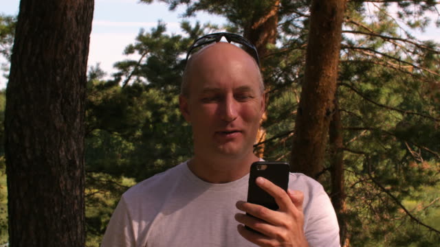 Erwachsenen-Mannes-reden-video-CAL-in-Handy-während-der-Reise-im-Sommer-Wald