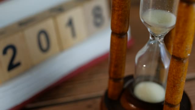 Close-up-View-of-Sand-in-hourglass-or-sandglass-for-time-counting-down-2018.-end-of-time
