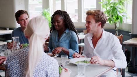 Gruppe-junger-Freunde-gemeinsame-Mahlzeit-im-Restaurant-genießen