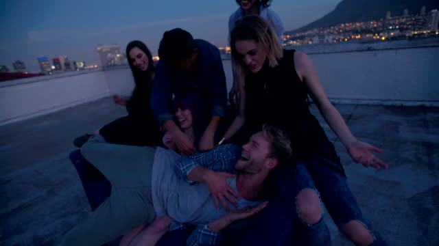Hipster-friends-dancing-and-talking-on-a-rooftop-party