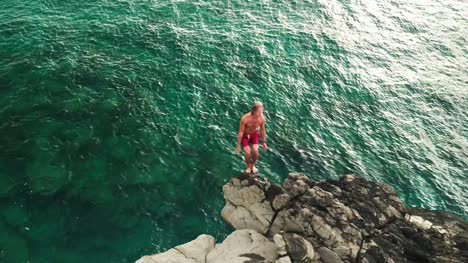 Aerial-view-cliff-jumping-into-ocean