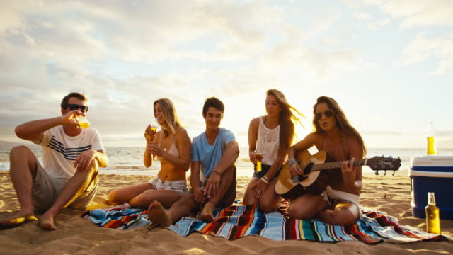 Friends-Relaxing-on-the-Beach-at-Sunset