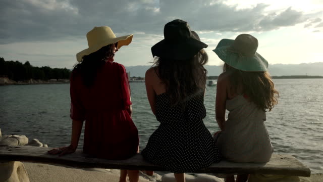 Girlfriends-at-beach-enjoying-sunrise-and-talking