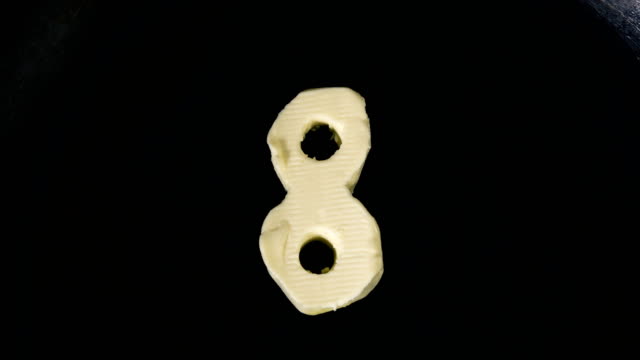 Countdown-animation-from-10-to-0-of-butter-in-shape-of-numbers-melting-on-hot-pan---Close-up-top-view