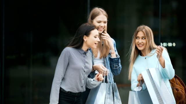 Three-young-women-sharing-their-new-purchases-with-each-other