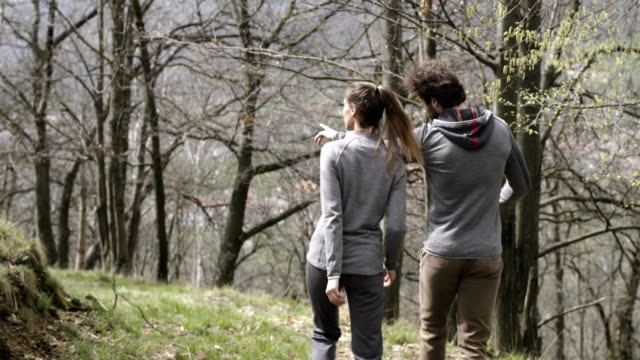 Man-and-woman-walking-and-hiking-in-birch-woods-forest.-following-behind.Couple-people-in-love-autumn-outdoor-trip-in-nature.-Fall-sunny-day.-4k-slow-motion-video