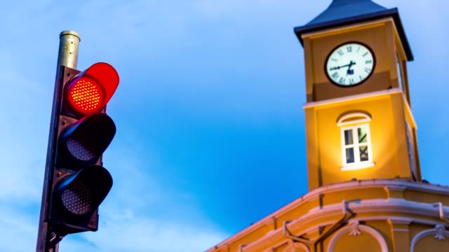 Traffic-light-with-clock-tower-in-color-of-sky-sunset-in-twilight