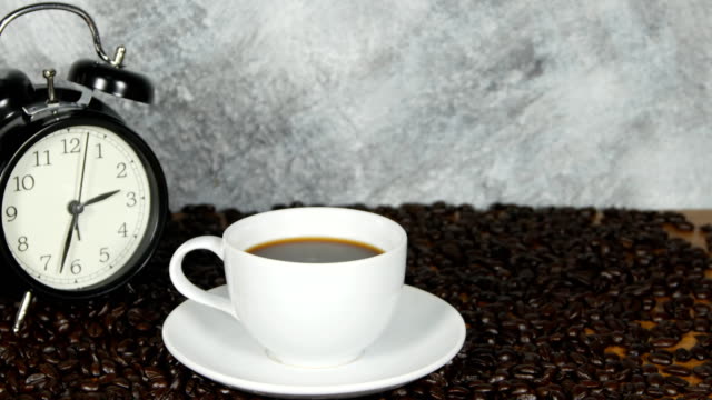 panorámica-de-tiro-de-la-taza-de-café-sobre-fondo-de-granos-de-café