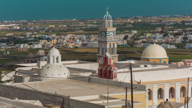 sunny-day-santorini-island-fira-town-church-clock-tower-rooftops-panorama-4k-time-lapse-greece