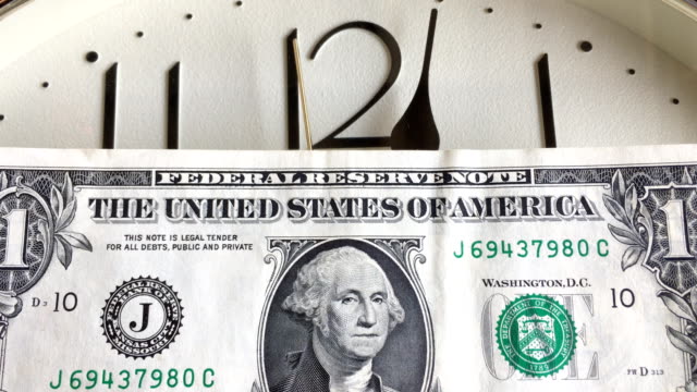 Nahaufnahme-f-uns-Dollar-Banknote-mit-Uhr-Hintergrund.