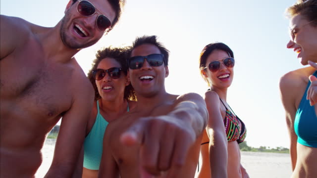 Multi-ethnischen-Freunde-mit-Bodyboards,-die-das-Strandleben-genießen
