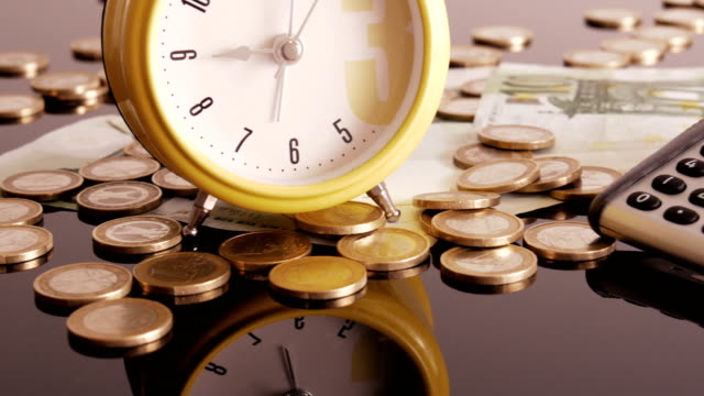 Alarm-clock-on-coins-and-banknotes