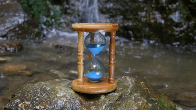 Hourglass-on-the-Background-of-a-Mountain-River