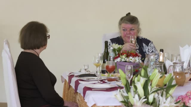 Seniors-celebrating-70th-anniversary-at-festive-dinner-table-in-restaurant
