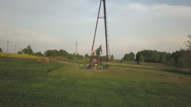 Öl-Pumpe-Station-und-Raps-Feld.