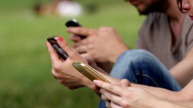 Hände-der-jungen-Studenten-im-Park-auf-die-Smartphones-tippen
