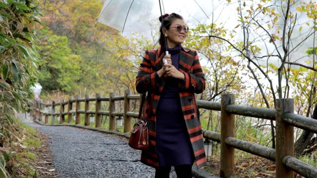 asian-woman-with-rain-umbrella-walking-in-jigoku-noboribetsu-one-of-most-popular-traveling-destination-hokkaido-japan