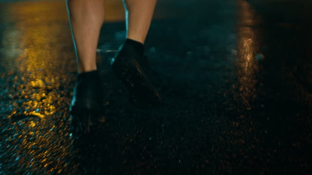 Close-Up-Leg-Shot-of-an-Athletic-Young-Man-in-Sports-Outfit-Jogging-in-a-Rainy-Street.-He-is-Running-in-a-Dark-Urban-Environment-Under-a-Brindge-with-Cars-in-the-Background.
