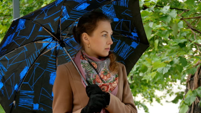 Schöne-Mädchen-versteckt-sich-vor-dem-Regen-unter-einem-Regenschirm