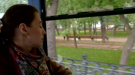 Schönes-trauriges-Mädchen-sieht-durch-das-Fenster-einer-Straßenbahn