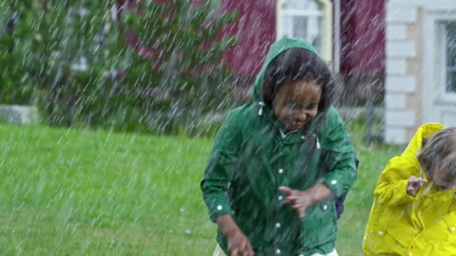 Glückliche-Kinder,-die-bei-starkem-Regen-läuft