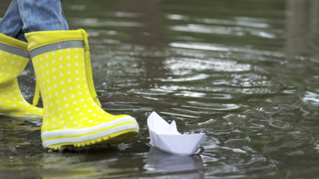 Kids-in-Rubber-Boots-Playing-with-Paper-Boats