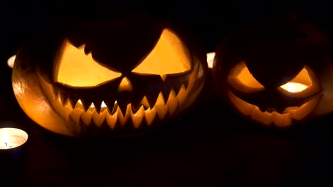 Two-pumpkins-are-on-the-table,-and-candles-are-burning-around.-Halloween-art-design.