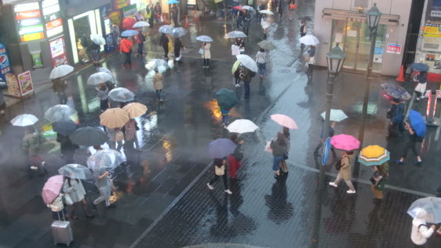 Menge-von-Menschen-zu-Fuß-mit-Sonnenschirmen-bei-Regen-auf-Dotonbori-Street,-Osaka,-Japan