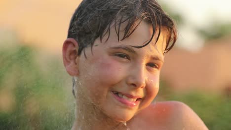 Portrait-of-child-outside-with-water-sprinkles---enjoying-the-simple-things-in-life-in-4k-clip-resolution