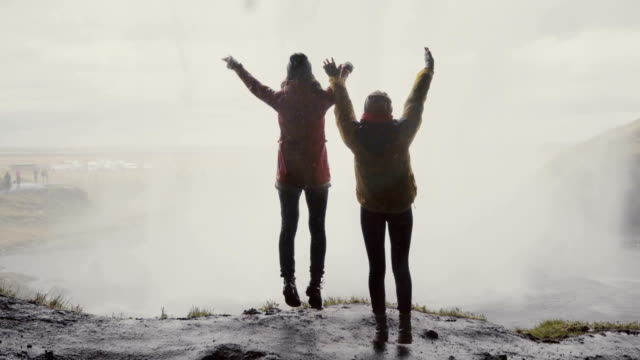 Rückseitige-Ansicht-von-zwei-weiblichen-Touristen-in-der-Nähe-der-Gljufrabui-Wasserfall-in-Island.-Frauen-der-Freude-in-der-Nähe-von-Augen-springen