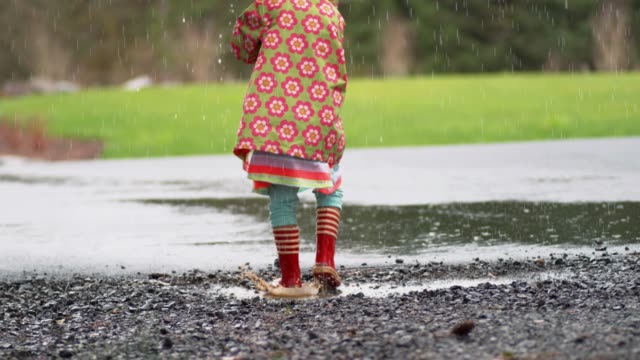 Junges-Mädchen-mit-Regenschirm-spielen-im-Regen,-Slow-motion