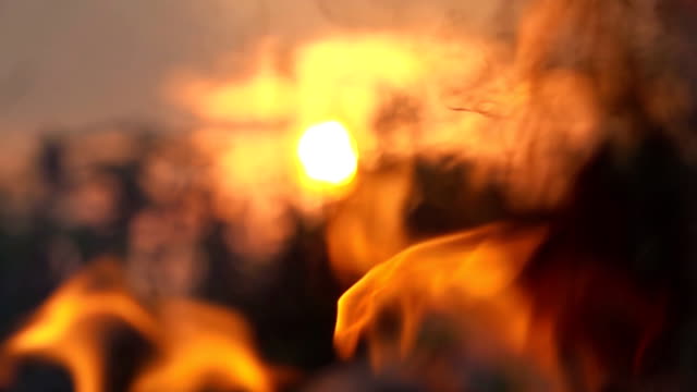 Slow-Motion-Flamme-Feuer.-Brennende-Flamme-des-Feuers-hautnah-auf-Sonne-Hintergrund
