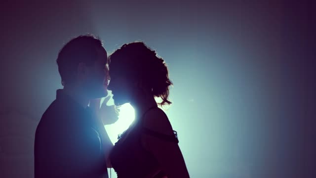 Dancers-in-love-cling-to-each-other-at-the-end-of-the-dance.-Silhouette-couple-ballroom.-Smoke