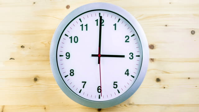 H24-horas-timelapse-sin-fisuras-bucle-listo,-movimiento-de-manos-del-reloj,-despertador-metálico-blanco-moderno-reloj-de-pared-en-madera