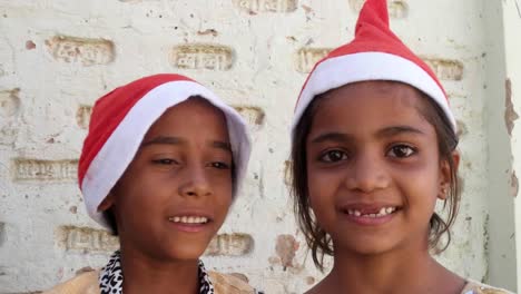 Cerca-de-dos-hermanas-de-niños-con-sombreros-de-Santa-sonriendo