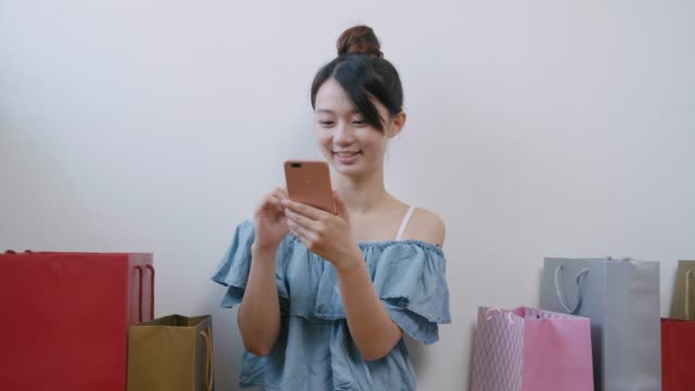 Woman-using-cellphone-while-shopping
