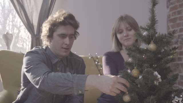 Junges-Paar-dekorieren-Weihnachtsbaum