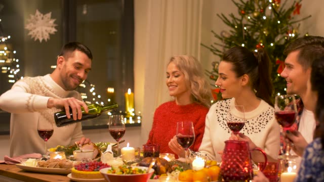 glückliche-Freunde-trinken-Rotwein-am-Weihnachtsessen