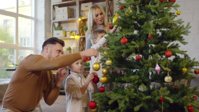 Glückliche-Familie-schmücken-Weihnachtsbaum