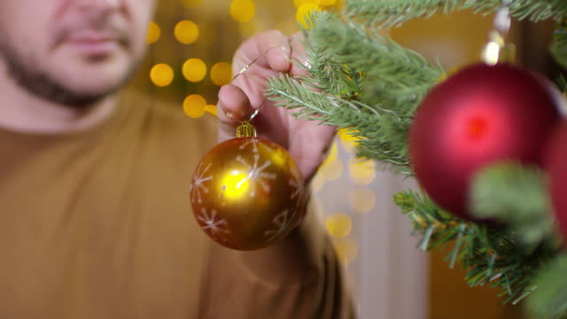 Mann-hängen-dekorative-Spielerei-am-Weihnachtsbaum