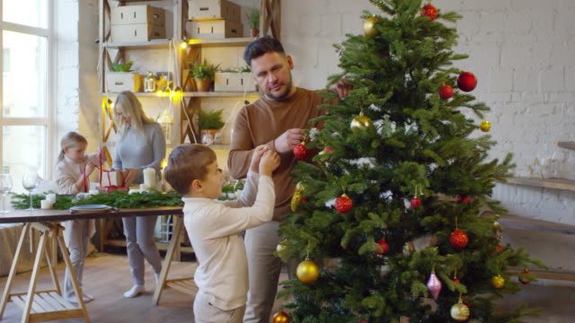 Kinder-helfen-Eltern,-Haus-für-Weihnachten-zu-verzieren