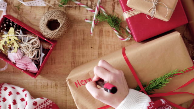 Woman-writing-'Merry-Christmas'-on-the-christmas-present