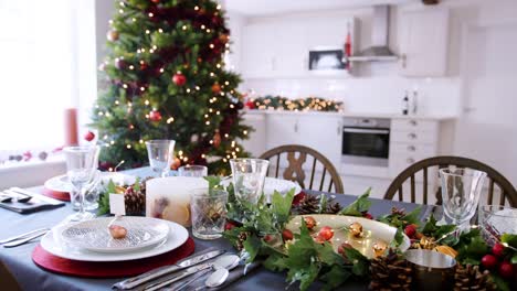 Festliche-Weihnachten-Esstisch-mit-Christbaumkugel-Name-Karteninhaber-auf-einer-Platte-und-grün-und-rot-Saisondekorationen,-erhöhten-Blick-angeordnet