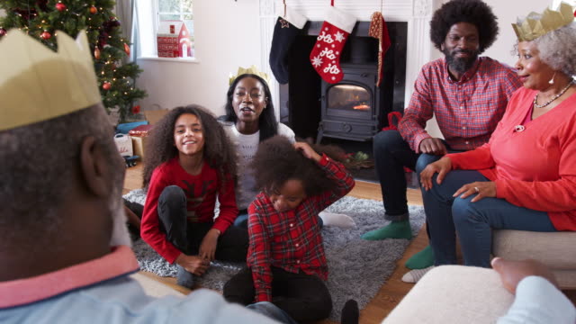 Multi-Generationen-Familie-sprechen-und-Geschichten-zu-erzählen,-wie-sie-Weihnachten-zu-Hause-zusammen-feiern