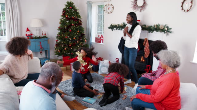 Niños-lanzando-papel-de-embalaje-en-el-aire-como-generación-de-Multi-familia-celebran-la-Navidad-juntos