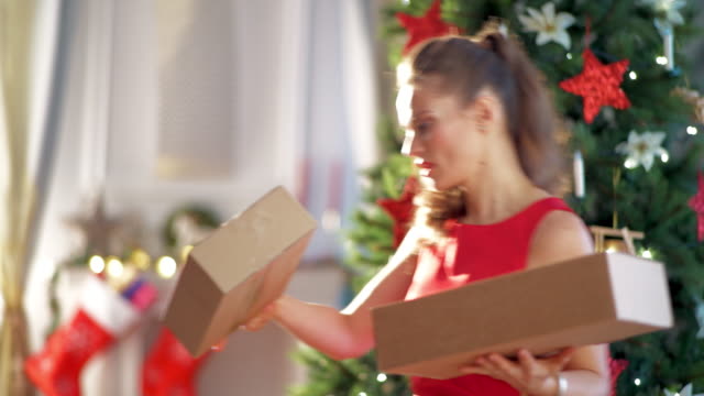 happy-trendy-housewife-with-parcels-near-Christmas-tree